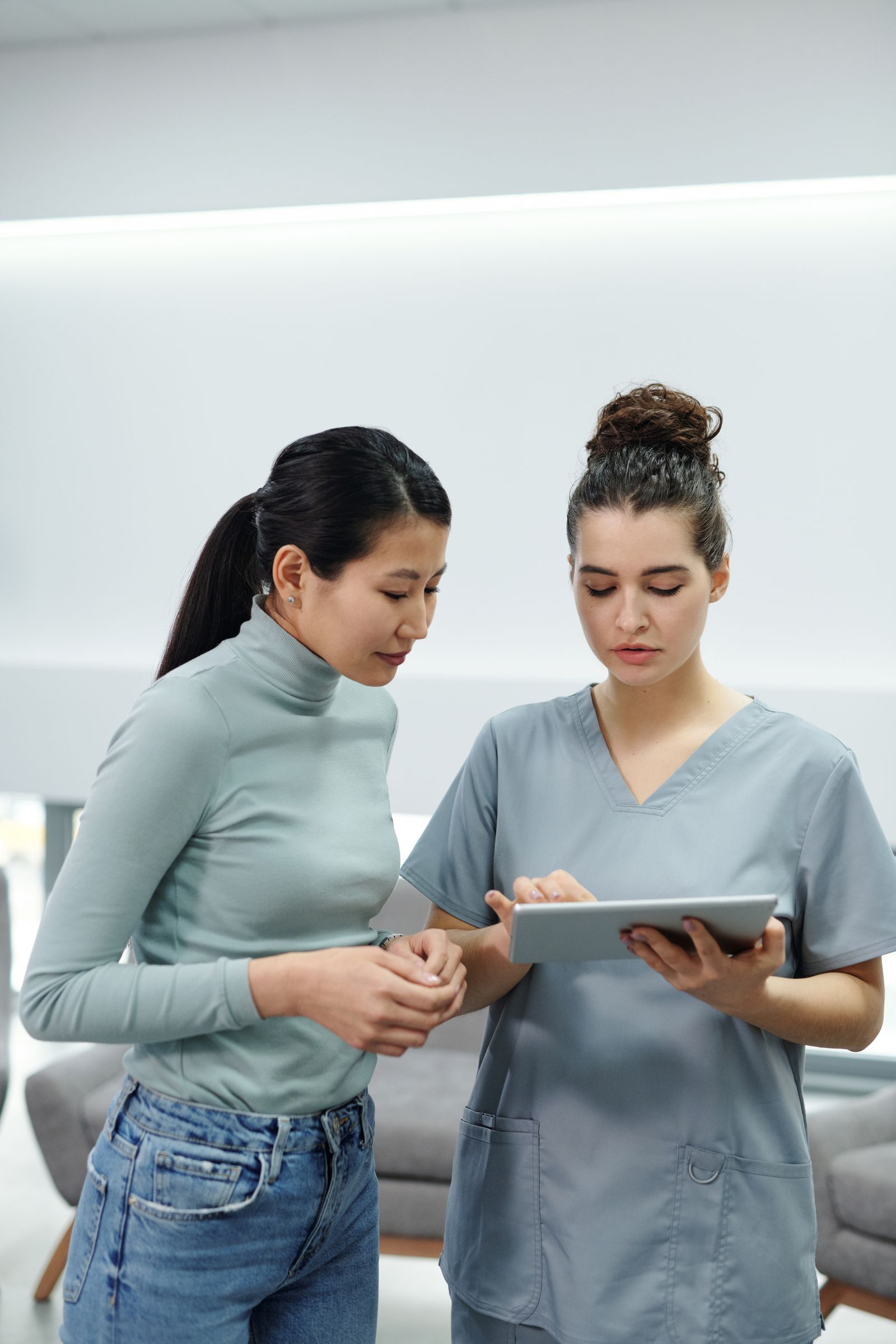 Soignante présentant le dossier patient sur tablette lors d'un échange